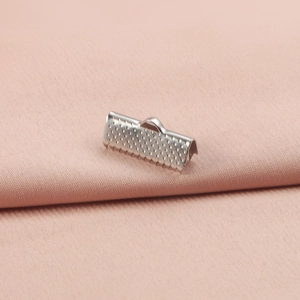 Close-up of silver stainless steel ribbon ends with textured surface and top hanging loop
