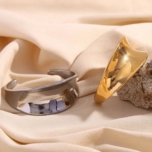 Polished 18K gold and silver wide geometric cuff bracelets on silk background