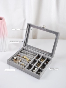 Macro view showing transparent glass lid, velvet ring slots, and removable dividers