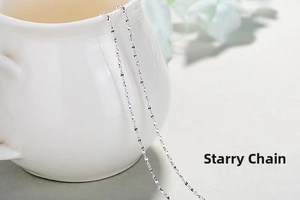 Detailed view of a silver starry chain draped over a white cup with floral accents