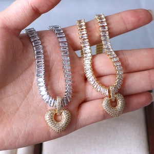 Elegant gold and silver heart pendant necklace featuring sparkling rectangle-cut cubic zirconia