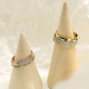 Minimalist titanium steel rings with micro-set zircon on wooden cone displays