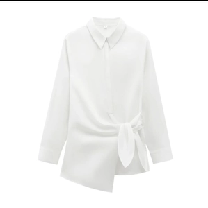 Minimalist white poplin shirt featuring a long sleeve design and asymmetric waist knot