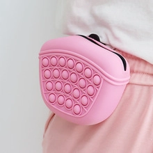 Close-up of a pink silicone fidget waist bag accessory worn on a trendy outfit