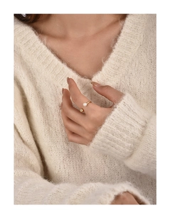 Detail of elegant gold open ring with white pearl and metal bead on model's hand