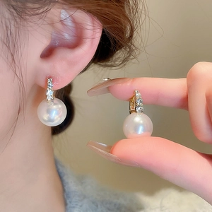 Detail of freshwater pearl flower earrings with gold plating and sparkling rhinestones