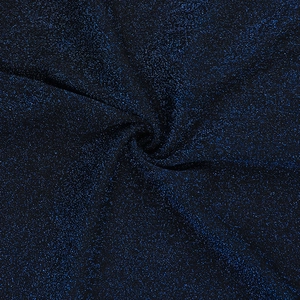Vue macro du tissu à paillettes bleu foncé avec des sequins et des plis drapés doux
