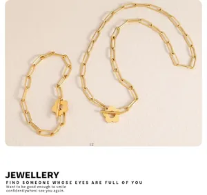 Detail of 18k gold plated paperclip chain jewelry set featuring floral OT toggle clasp
