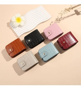 Close-up of mini PU leather lipstick pouches in various colors with crocodile texture
