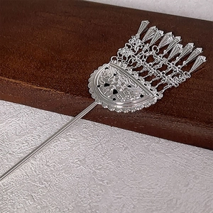 Silver ethnic style hair stick with flower petals and tassels on a stone base