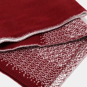 Detail of burgundy knit scarf with soft jacquard heart pattern and thick winter texture