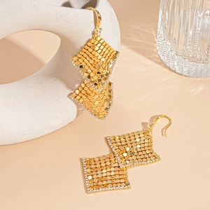 Detail of 18k gold plated geometric mesh earrings with zircon accents on beige background