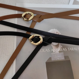 Close-up of black and brown leather belts featuring unique gold irregular oval buckles