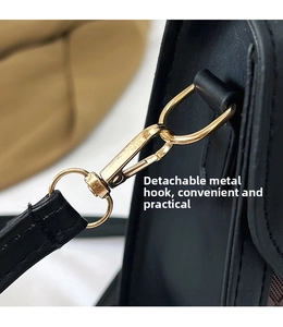 Détail du fermoir mousqueton doré amovible et quincaillerie sur sac noir matelassé