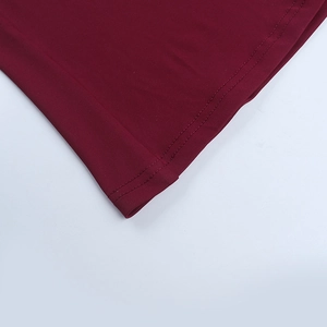 Macro shot of precise double-needle stitching on the hem of a burgundy evening dress