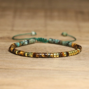 Detailed close-up of tiger eye and turquoise beads with adjustable woven strap