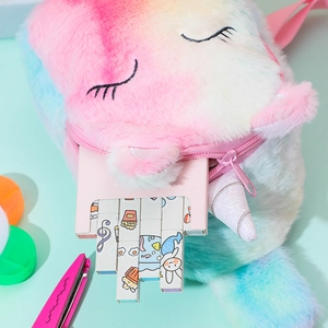 Detail of plush unicorn pencil case with rainbow fur and sparkling horn holding stationery