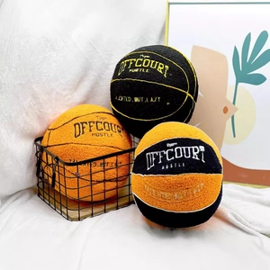 Three plush basketball pillows in orange and black with embroidered motivational quotes