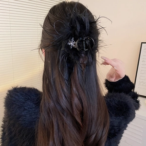 Détail d'une pince à cheveux noire en plumes d'autruche avec pampille flocon de neige