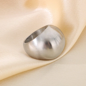 Nahaufnahme eines breiten silbernen Edelstahlrings mit gebürstetem Finish auf Stoff