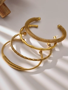 Detailed view of three 18k gold plated stainless steel bangles with diverse textures