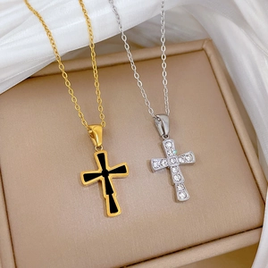 Macro shot of gold cross with black inlay and silver cross with sparkling rhinestones