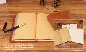 Detail view of brown leather travel notebook with kraft paper inserts and pen set