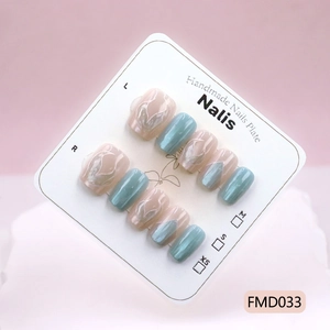 Cat eye mermaid tail press-on nails with blue shimmer and marble design on display card