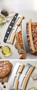 Macro shot of curved stainless steel pizza rocker knife with durable wooden handle