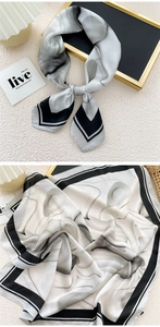 Detail of silk square scarf showing black and white floral print and satin texture