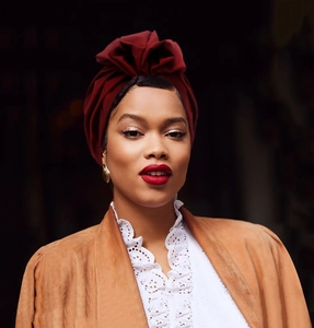 Detail of burgundy turban cap with elegant pleated design and soft fabric texture