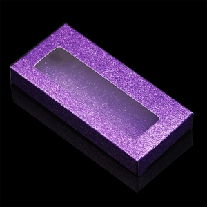 Close-up of purple glitter rectangle eyelash box with transparent window on black background
