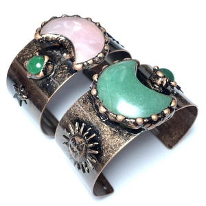Makro-Detail von Retro-Bronze-Manschettenarmbändern mit Mondsteinen und Sonnenmotiven