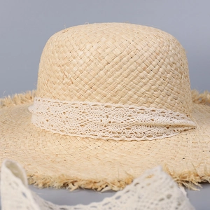 Women's beige straw sun hat with white lace ribbon and frayed brim for beach vacation