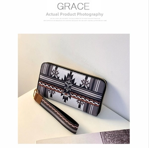 Detail of geometric pattern long wallet with wrist strap and gold zipper closure