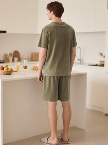 Rear view of olive green short-sleeve loungewear set in a modern white kitchen