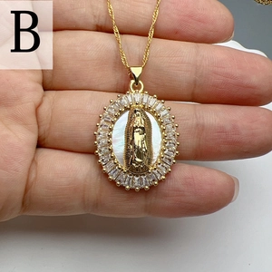Macro shot of gold Virgin Mary pendant with baguette crystals and white pearl base