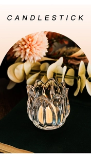 Close-up of a tulip-shaped glass candlestick with a glowing lit candle inside
