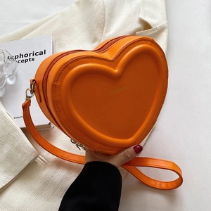 Dettaglio della borsa a tracolla arancione a forma di cuore con texture in rilievo