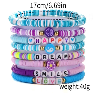 Detail of colorful polymer clay bead bracelets with gold accents and positive letter beads