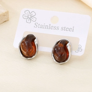 Detail of amber resin stud earrings with irregular silver stainless steel base
