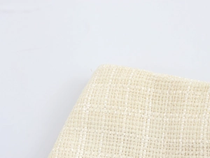 Gros plan sur l'élégant tissu en tweed beige montrant la texture tissée de qualité