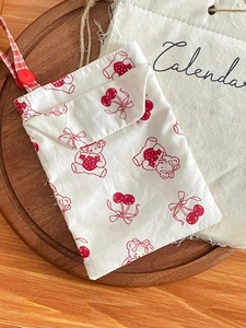 Detail of red rabbit nurse stationery bag with bear patterns, wooden tray background