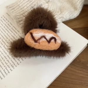 Detailed view of coffee brown acrylic hair claw with soft flocking and plush bread decoration