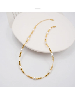 Detailed macro view of French style gold beaded necklace with elegant white pearls