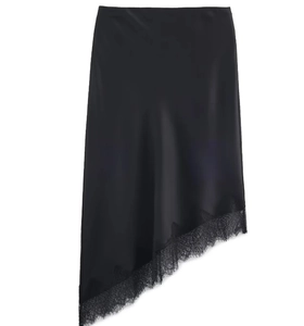 Détail d'une jupe midi en satin noir avec ourlet asymétrique et bordure en dentelle