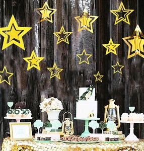 Close-up of golden 3D paper star decorations on a festive party dessert table