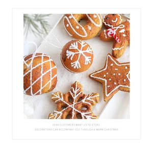 Macro shot of gingerbread man and snowflake foam ornaments on festive white snow background