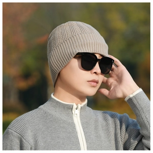 Close-up of light khaki winter knit beanie showing vertical ribbed texture and cuff detail