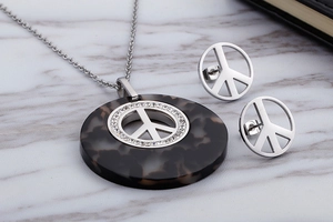 Detail of vintage gold peace sign jewelry set with resin inlay and sparkling rhinestones